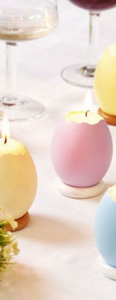 several candles are sitting on a table with wine glasses