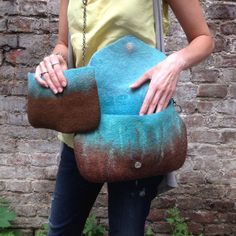 a woman holding a blue and brown purse