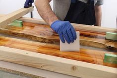 a man in blue gloves waxing wood