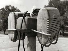 an old fashioned phone is attached to a pole with two wires in the middle of it