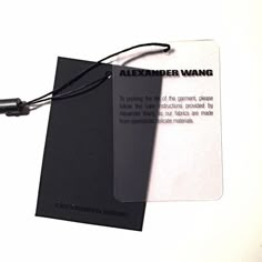 a black and white photo of a name tag with a cord attached to the tag