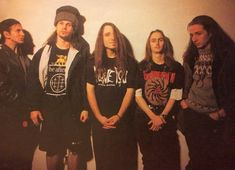 a group of young men standing next to each other in front of a white wall