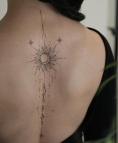 the back of a woman's shoulder with a sun and stars tattoo on it