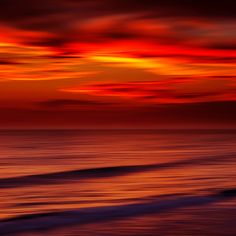 an orange and red sunset over the ocean