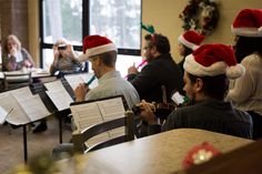 a group of people wearing santa hats and playing musical instruments