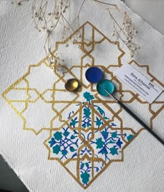 a table topped with lots of different items on top of a white cloth covered in gold and blue designs