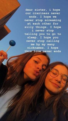 two young women are holding an umbrella and looking at the sky with their eyes closed