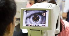 a man is looking at an eye scan machine