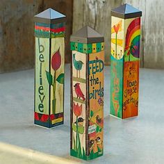 three colorful wooden boxes with birds and flowers painted on them