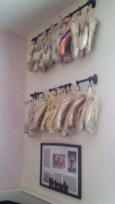 there are several pairs of shoes hanging on the wall next to a framed photo and pictures