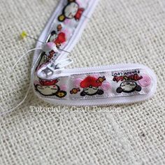 a pair of scissors with hello kitty designs on them sitting on a piece of fabric