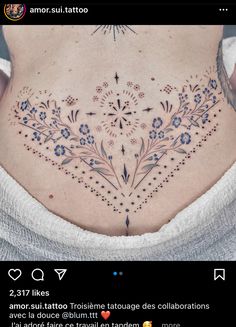 the back of a woman's stomach with an intricate tattoo design on her ribs