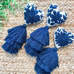 four blue and white tasselled pieces on a woven mat