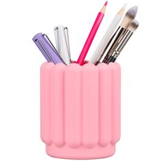 a pink cup filled with different types of makeup brushes