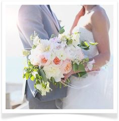 a bride and groom posing for a wedding photo on the boardwalk at their beachside wedding