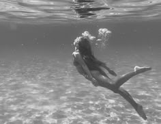 a woman is floating in the water with her legs spread out as she swims