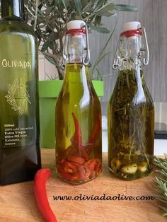 three bottles filled with different types of herbs and spices sitting on a table next to a potted plant