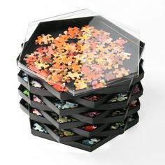 a stack of puzzle pieces sitting on top of each other in a black box,