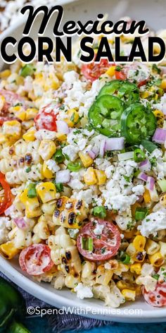 mexican corn salad in a white bowl with tomatoes and green peppers