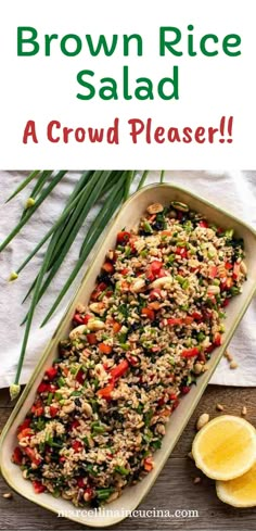 brown rice salad in a casserole dish with lemons on the side