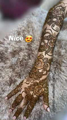 a woman's hand with henna on it and the words nice written in arabic