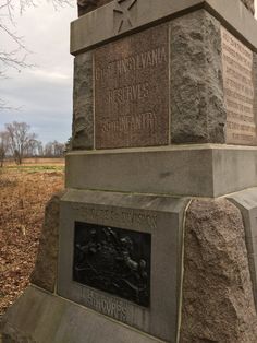 the monument has two heads on it and is in front of a field with dead grass