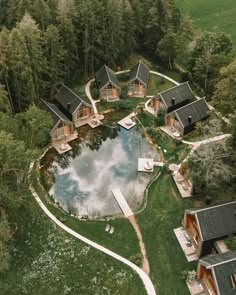 an aerial view of a house in the middle of a wooded area with a pond