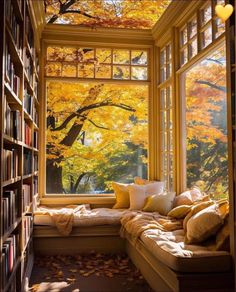 a window seat in front of a book shelf filled with books