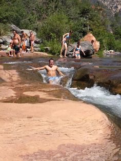 a man swimming in a river surrounded by people