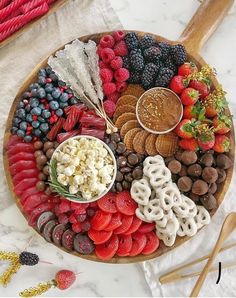 a wooden platter filled with fruit and crackers