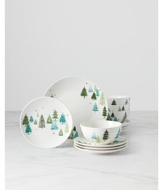 a set of christmas tree dishes on a marble countertop with white and green accents