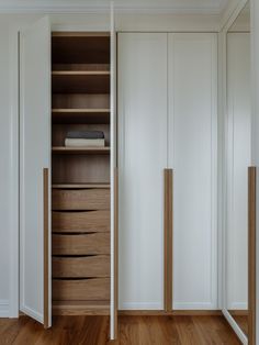 an empty closet with wooden drawers and white walls