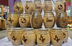 many wooden barrels are stacked on top of each other in front of a display case