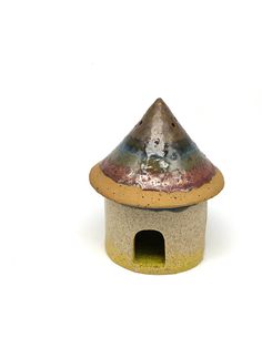 a ceramic birdhouse with a brown roof on a white background in the shape of a house