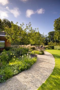 a garden with gravel path leading to a building