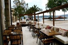 tables and chairs are lined up on the outside patio by the water's edge