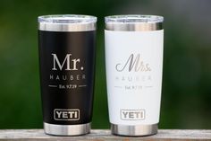 two personalized yeti cups sitting on top of a wooden table next to each other