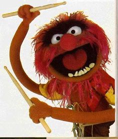 the muppet is holding a stick and pointing it at something with its right hand