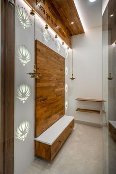 a large wooden door sitting inside of a white room next to a wall with lights on it