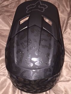 the helmet is black with silver glitters on it's face and features a leopard print