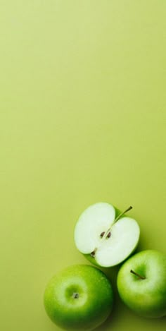 three green apples sitting on top of each other next to an apple in the middle