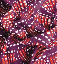 a purple and red patterned fabric with white dots on the top, in an abstract pattern