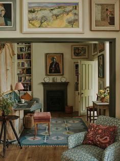 a living room filled with furniture and pictures on the wall above it's fireplace