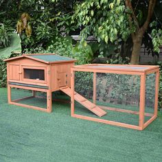 two large wooden chicken coops in the grass