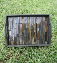 a mosaic tile tray sitting in the grass