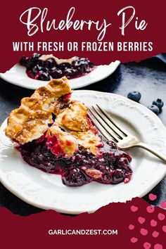 blueberry pie with fresh or frozen berries on a white plate next to a fork