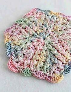 a crocheted dishcloth is shown on a white surface with blue, pink, and green colors