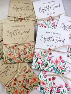 wedding favors are tied up with twine and flowers on the tags that say, love is blooming christ & david