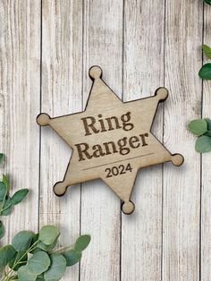 a wooden star ornament with the name ring ranger on it next to some green leaves