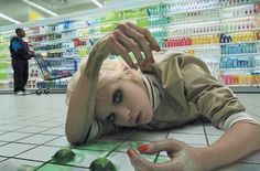 a woman laying on the ground in front of a store display